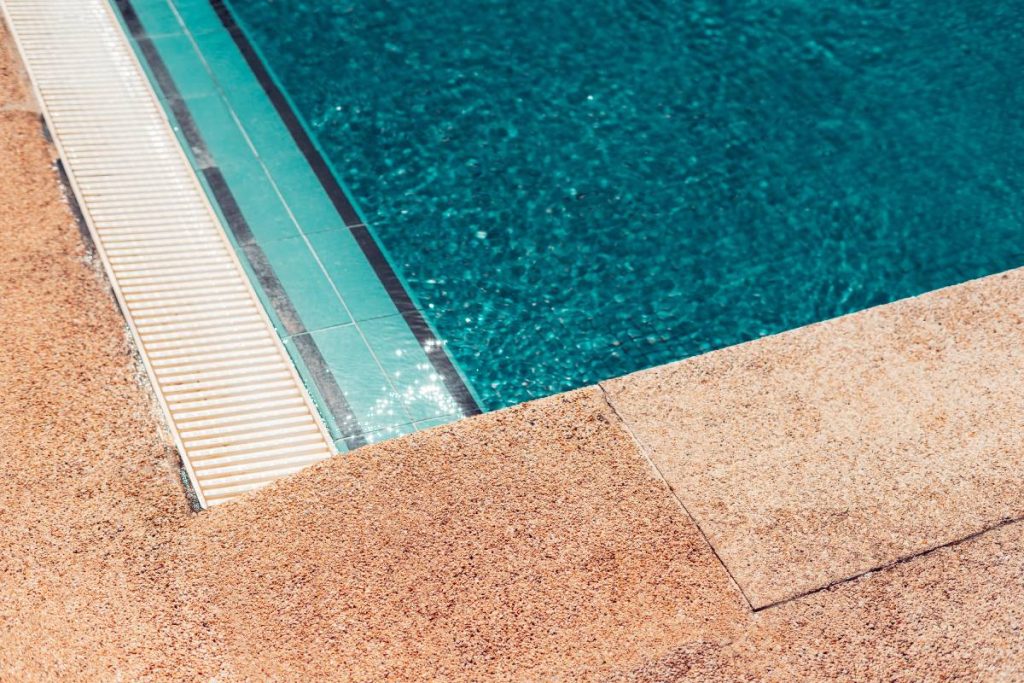 Detail of a swimming pool with filters on the sides and stone borders