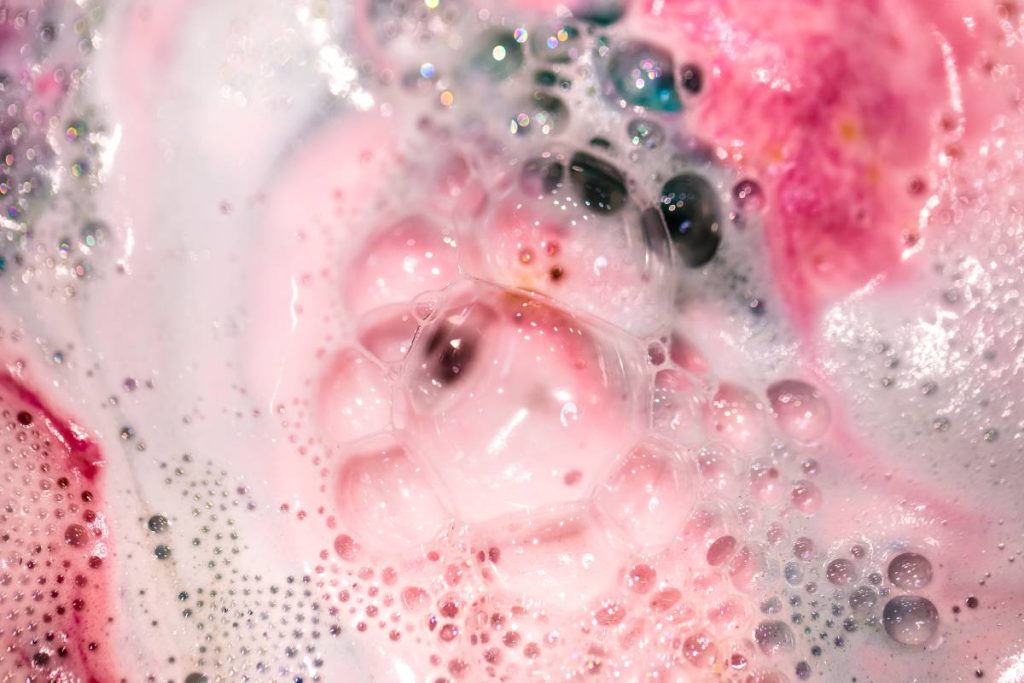 The bright bath bomb dissolves in water . The concept of body care . Handmade cosmetics .