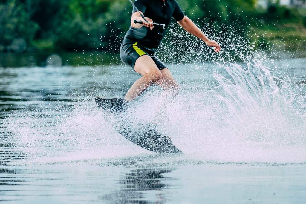 man jumps on wakeboard wave. summer lake
